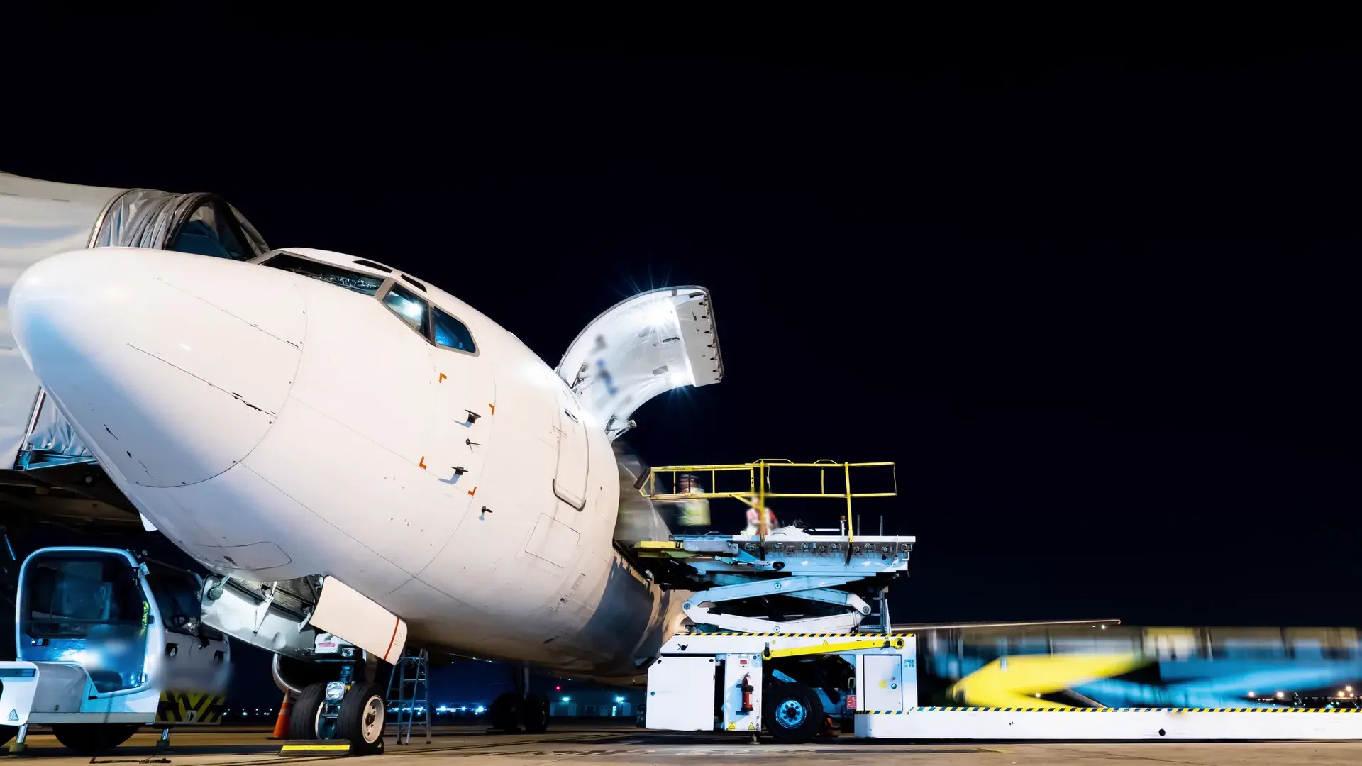 Industrial cargo being loaded into a freight aircraft at night
